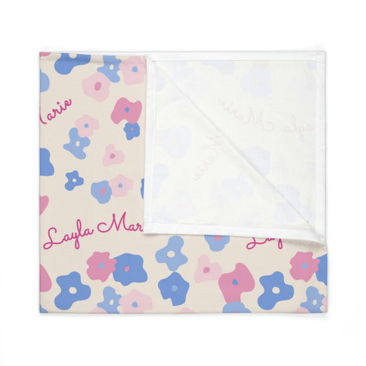 Folded jersey fabric personalized baby blanket in graphic pink and blue daisy pattern
