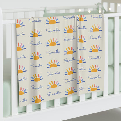Jersey personalized baby blanket in sun pattern hung over side of white crib