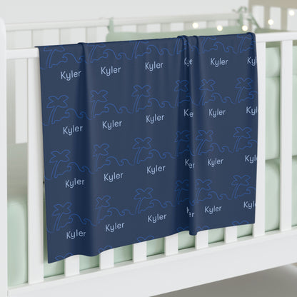 Jersey personalized baby blanket in surf and palm tree pattern hung over side of white crib
