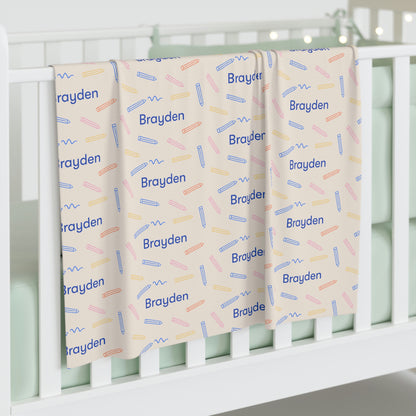 Jersey personalized baby blanket in colored pencil pattern hung over side of white crib