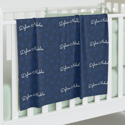 Jersey personalized baby blanket in stars and moon pattern hung over side of white crib