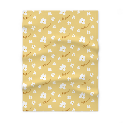 Fleece personalized baby blanket in yellow daisy pattern laid flat