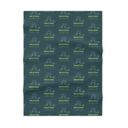 Fleece personalized baby blanket in green mountain adventure pattern laid flat