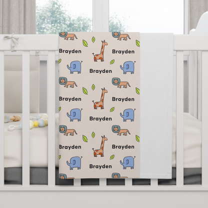 Fleece personalized baby blanket in safari animal pattern hung over side of white crib with window in the background